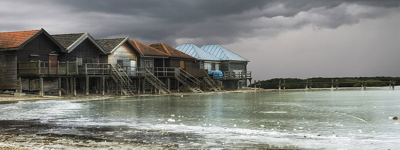 wooden houses beside body of water thumbnail