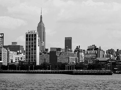 grayscale photo of city buildings near body of water thumbnail