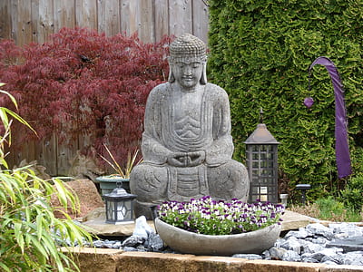Gautama Buddha statue surrounded of plants thumbnail