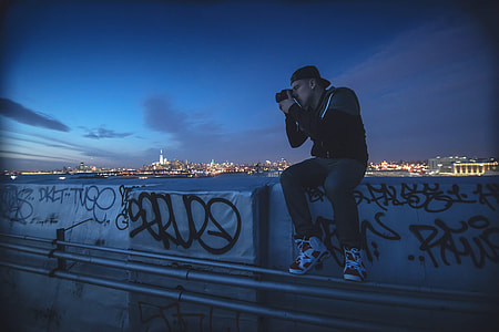 A man takes a photo at night in New York thumbnail