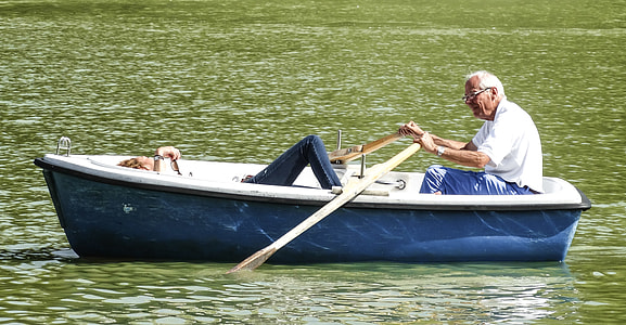 man in white polo shirt in blue boat holding paddle during daytime thumbnail