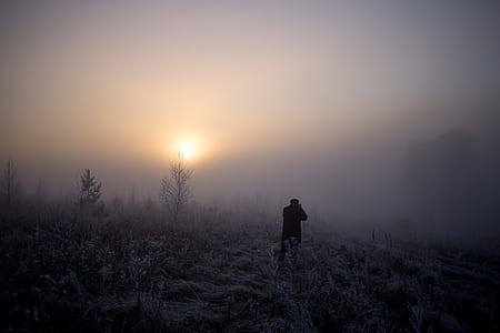 silhouette of man standing on snowfield thumbnail