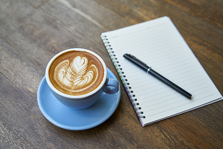 Cappuccino artwork near on notebook and pen thumbnail
