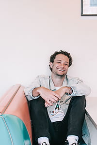 man sitting on chair while sitting in the room thumbnail