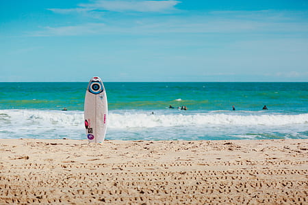 white surfboard on seashore thumbnail