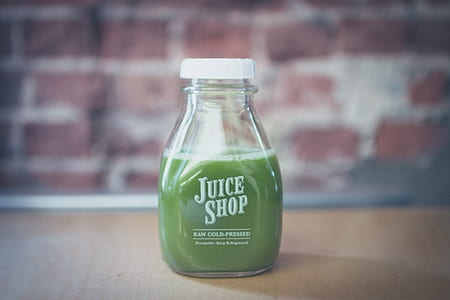 selective focus shot of Juice Shop bottle on brown wood surface thumbnail