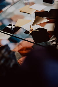Women folding sheet of paper while making origami thumbnail