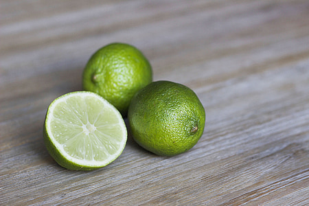 three green calamundin fruits on brown surface thumbnail