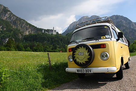yellow Volkswagen Kombi parked beside grass field thumbnail