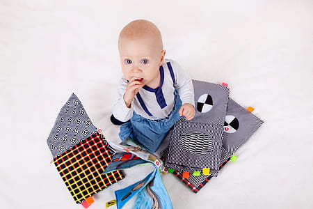 baby sitting on white textile photography thumbnail