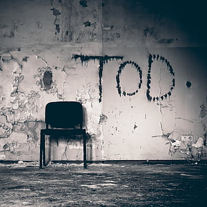 black metal armless chair near gray wall thumbnail