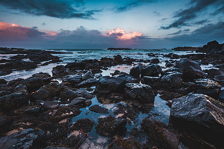 rocks in ocean during golden hour thumbnail