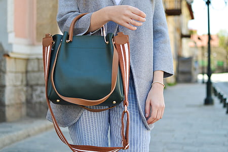 woman standing while holding handbag thumbnail