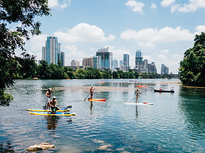 group of people riding paddle boards under blue sky thumbnail