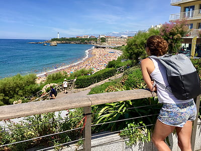 Woman In White Tank Top Leaning On Railing thumbnail