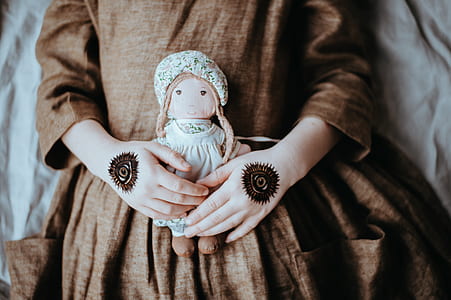 person holding brown and white doll thumbnail