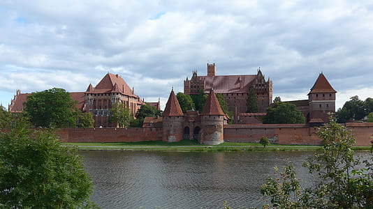 brown concrete building beside body of water thumbnail