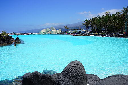 photo of swimming pool near forest and rock formation thumbnail