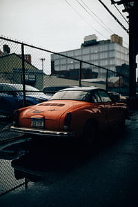 classic red coupe under gray sky thumbnail