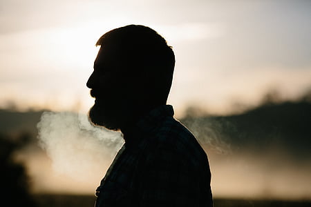 silhouette of a man smoking during day time thumbnail