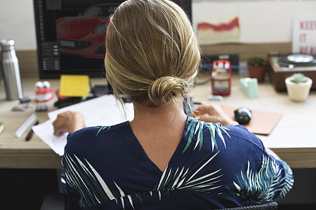 woman sitting in front of desk holding papers thumbnail