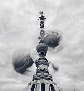 grayscale photo of tower under cloudy sky thumbnail