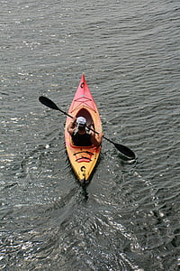 man riding red kayak on body of water thumbnail