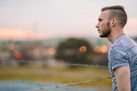 man standing near gray barbwire during daytime thumbnail
