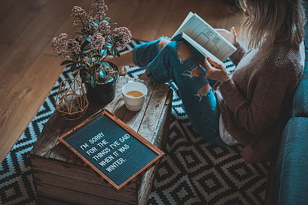 woman wearing brown cardigan holding book thumbnail