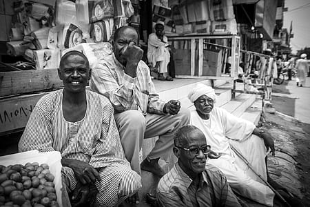 grayscale photography of four men sitting on stairs thumbnail