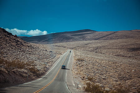 black car traveling on road thumbnail