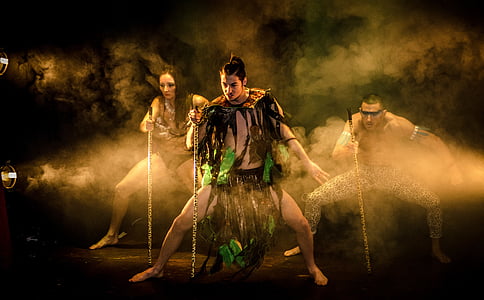 two men and one woman wearing amazonian costume holds staff thumbnail