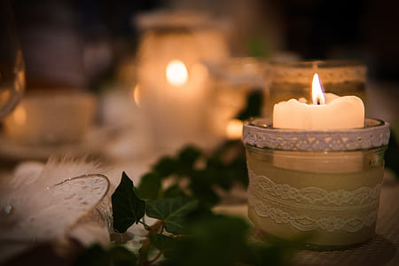 lighted white tealight candle in closeup photography thumbnail