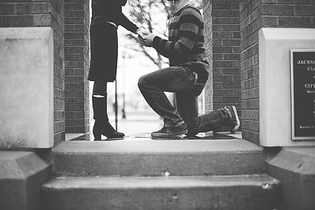 person kneeling in front of person on the ground thumbnail