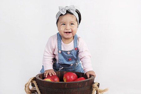 baby wearing pink long sleeved shirt and blue overall pants thumbnail