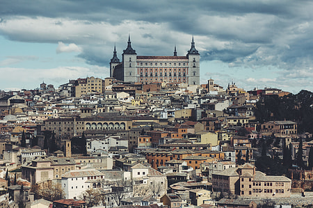 aerial view of town under cloudy skies during daytime thumbnail