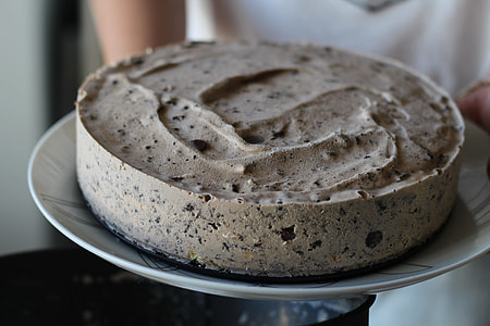 person holding cookies and cream cake served on plate thumbnail
