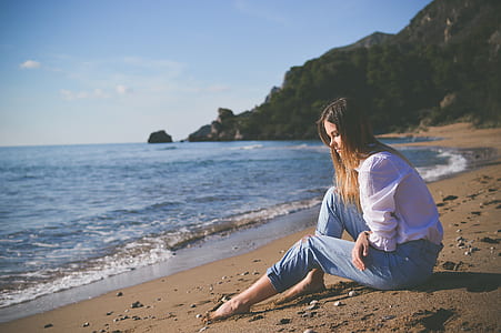 woman sitting near seashore thumbnail