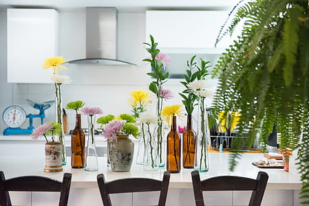 clear glass vases with flowers on table thumbnail