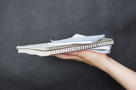 person holding spiral notebook thumbnail