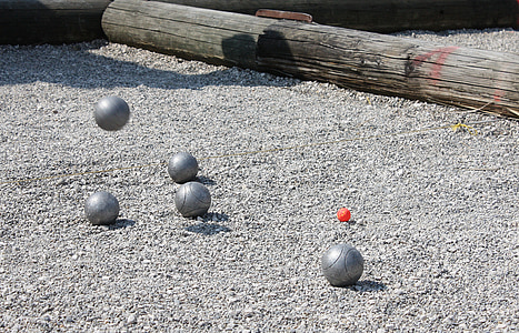 five gray metal balls on gray sand thumbnail