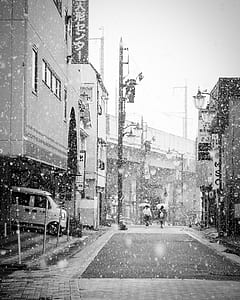 grayscale and time lapse photo of two couple walking and holding umbrella while its raining thumbnail
