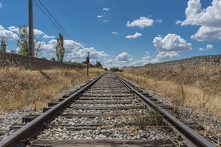 black and gray railway between brown grasses under clear blue sky during daytime thumbnail
