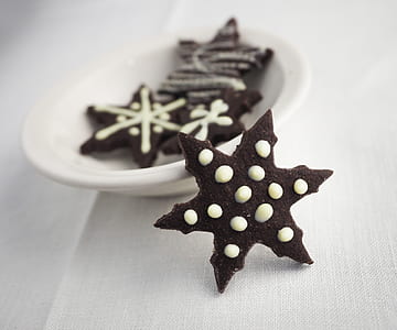 snowflake-shaped chocolate cookies on white ceramic saucer thumbnail