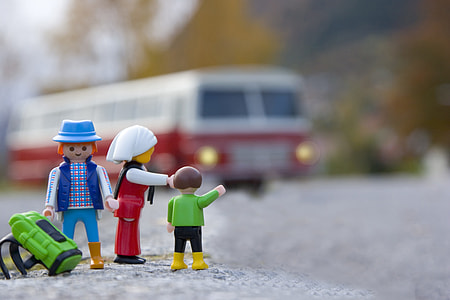 selective focus photography of three plastic toys near bus thumbnail