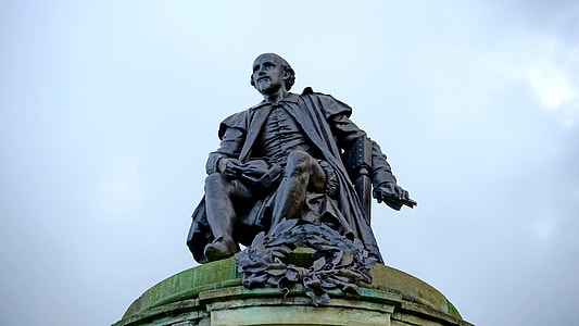 man sitting on chair statue under cloudy daytime thumbnail