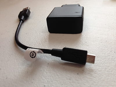 black travel adapter with micro-USB cable on white surface thumbnail