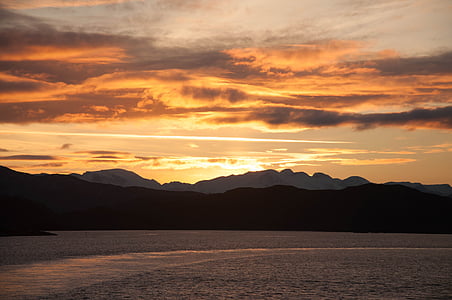body of water and mountain hills at golden hour thumbnail