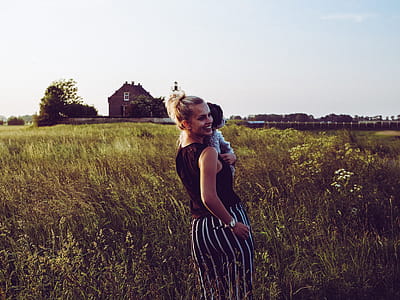 Mother and Child Walking on the Grass Field thumbnail