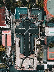 aerial photography of cross shape cathedral surrounded by basketball, tennis courts and buildings thumbnail